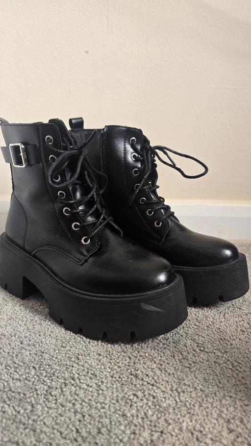  — Black chunky platform ankle boots.