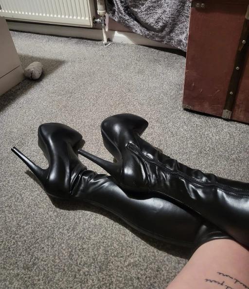  — Worn black thigh high boots