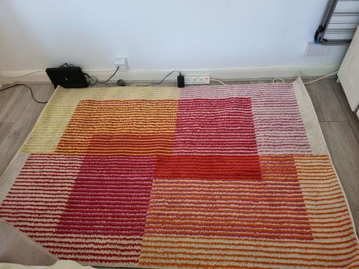  — Cosy red, yellow, and orange rug